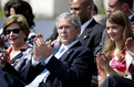 Laura Bush, George W. Bush and Urška Bačovnik are watching the programme of the Lipica Stud Farm Riding School